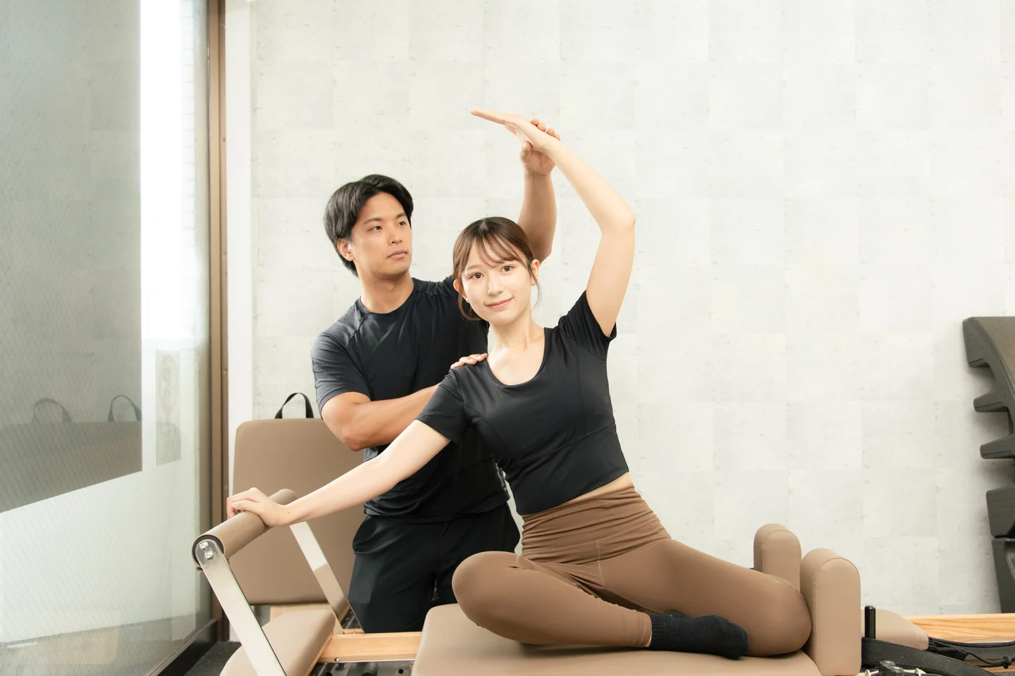 LEPO GYMでトレーナーがマシンピラティスの動きをサポートする様子